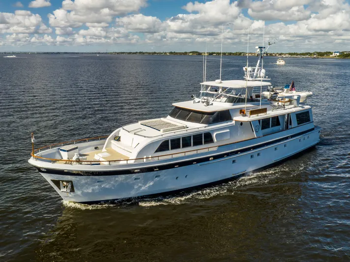  Yacht Photos Pics 1985 Cheoy Lee 90 Motor Yacht cruising on open water under a partly cloudy sky.