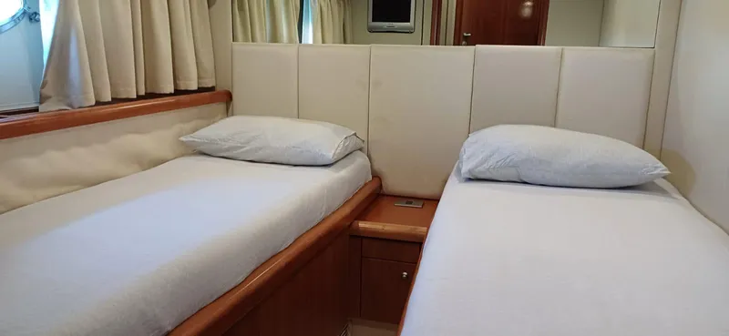 Yacht Photos Pics Twin beds in a 2006 Sunseeker Manhattan 60 yacht cabin, featuring white bedding and wooden accents.