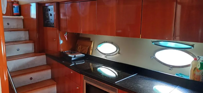  Yacht Photos Pics Interior of 2006 Sunseeker Manhattan 60 yacht with wooden cabinets and porthole windows.