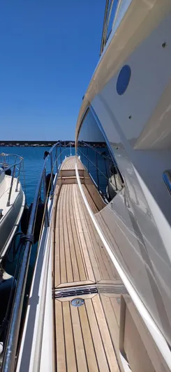  Yacht Photos Pics Sunseeker Manhattan 60 yacht, 2006 model, sleek deck view, docked by clear blue water.