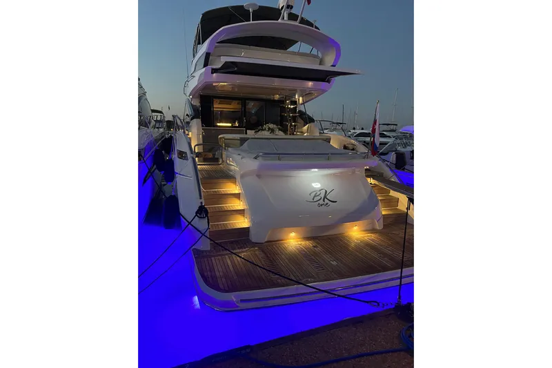  Yacht Photos Pics Luxurious 2022 Princess S66 yacht with illuminated deck at dusk in marina.