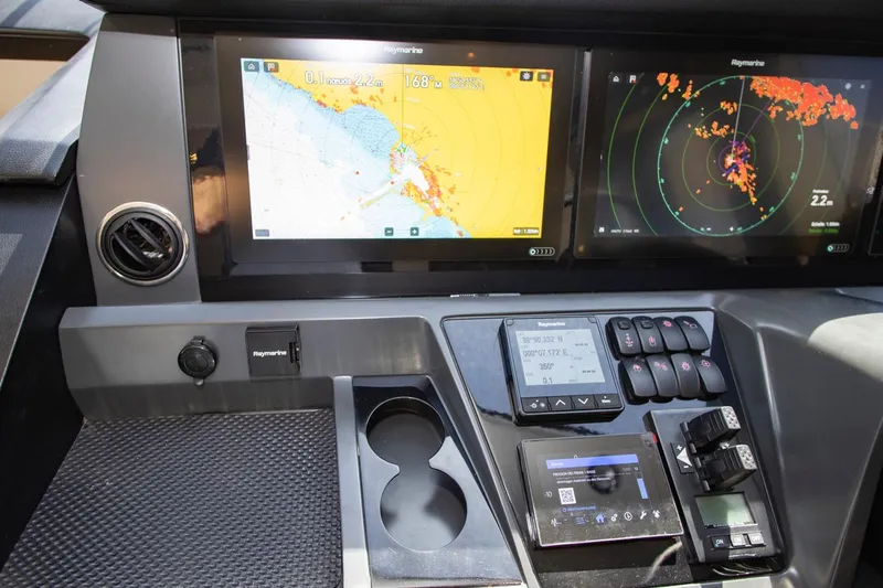  Yacht Photos Pics Control panel of a 2022 Princess S66 yacht with navigation displays and controls.