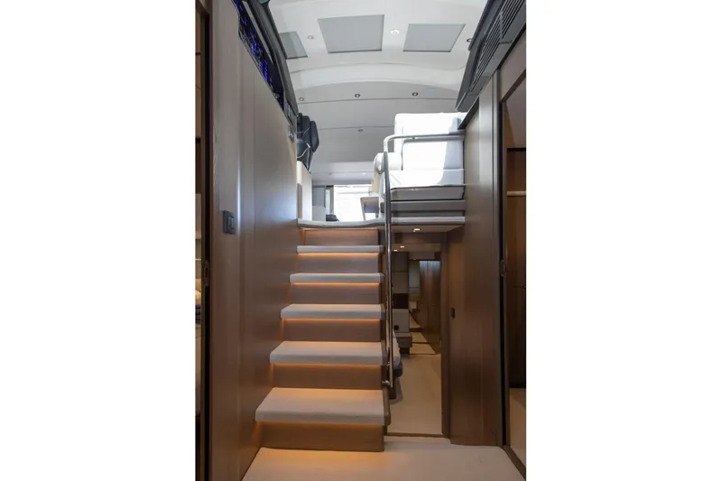  Yacht Photos Pics Interior staircase of 2022 Princess S66 yacht, featuring modern design and ambient lighting.