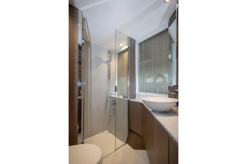  Yacht Photos Pics Luxurious bathroom in 2022 Princess S66 yacht with modern fixtures and glass shower.