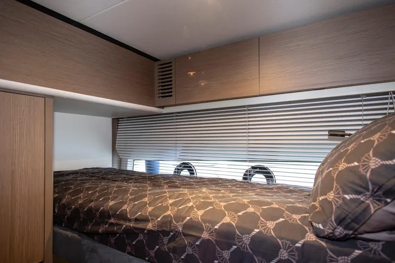  Yacht Photos Pics Luxurious cabin interior of 2022 Princess S66 yacht with modern bedding and wooden cabinetry.