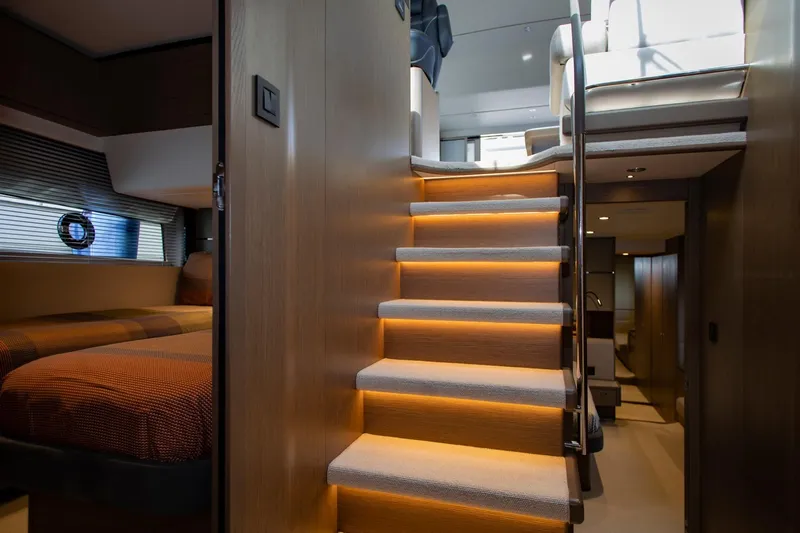  Yacht Photos Pics Luxurious interior of 2022 Princess S66 yacht with illuminated staircase and cozy cabin.