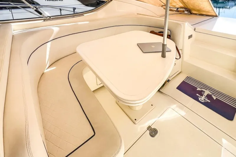  Yacht Photos Pics Luxurious seating area on a 2001 Cantieri di Sarnico 45 yacht with a table and laptop.