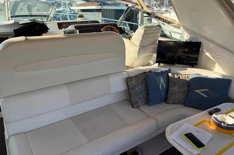  Yacht Photos Pics Interior of 1998 Sea Ray 400 Sundancer yacht with white seating, cushions, and a small TV.