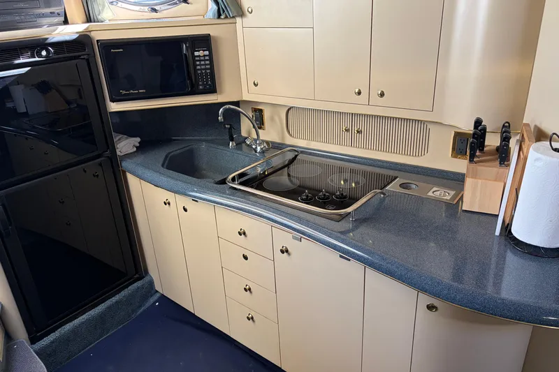  Yacht Photos Pics 1998 Sea Ray 400 Sundancer yacht kitchen with stove, sink, microwave, and cabinets.