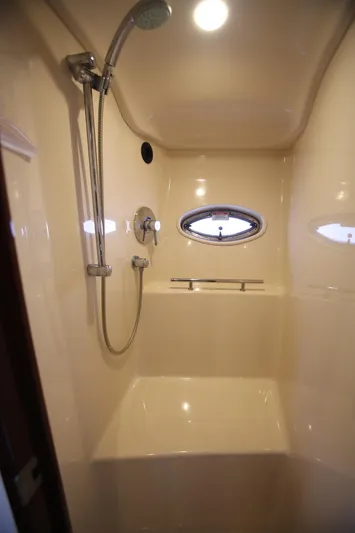 Missy Yacht Photos Pics Shower area in 2010 Sea Ray 390 Sundancer yacht with porthole and modern fixtures.
