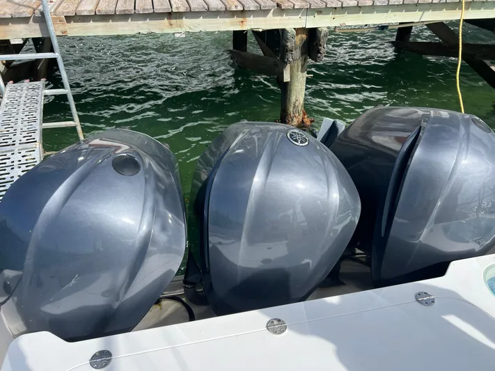  Yacht Photos Pics Three powerful outboard motors on a 2014 Everglades 350LX boat docked by the water.