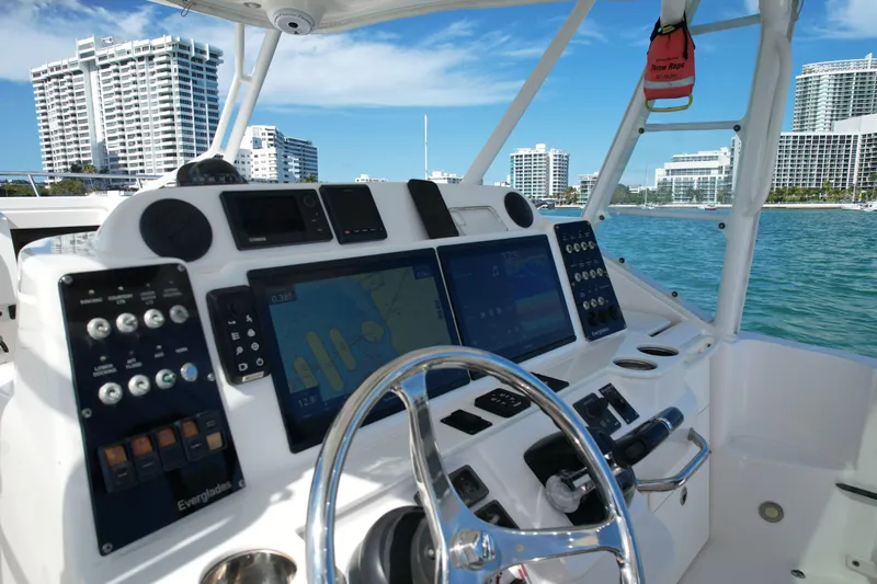  Yacht Photos Pics Cockpit of 2014 Everglades 350LX boat with navigation screens, steering wheel, and city skyline.
