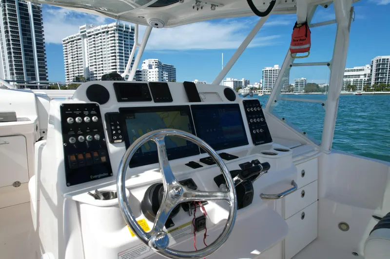  Yacht Photos Pics Cockpit of 2014 Everglades 350LX boat with modern controls, city skyline in background.