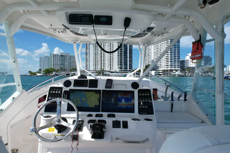  Yacht Photos Pics Cockpit view of 2014 Everglades 350LX boat with city skyline in background.