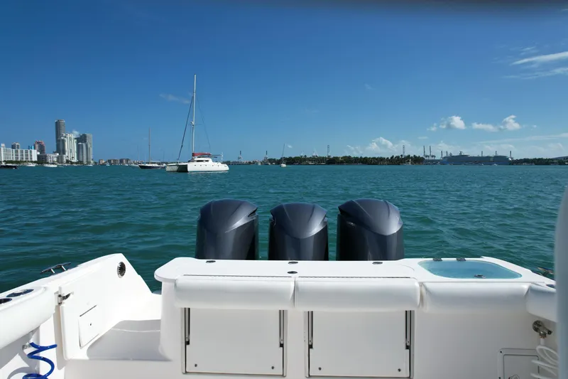  Yacht Photos Pics 2014 Everglades 350LX boat with triple engines on a sunny day, city skyline in background.