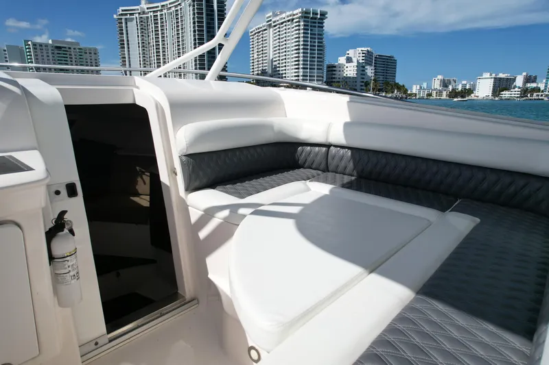  Yacht Photos Pics 2014 Everglades 350LX boat interior with cushioned seating, city skyline in background.