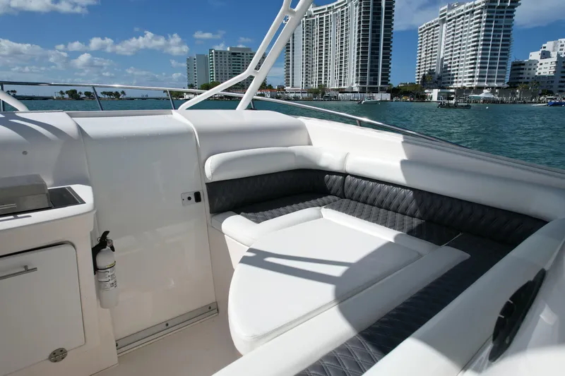  Yacht Photos Pics 2014 Everglades 350LX boat interior with cushioned seating, city skyline, and ocean view.