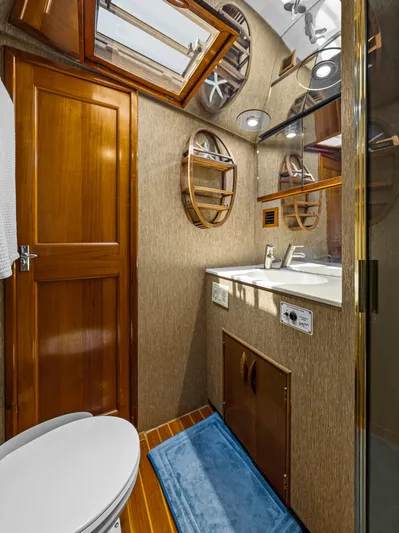 Vintage 1990 Yacht Photos Pics 1990 Buddy Davis 61 Convertible yacht bathroom with wooden cabinetry and modern fixtures.