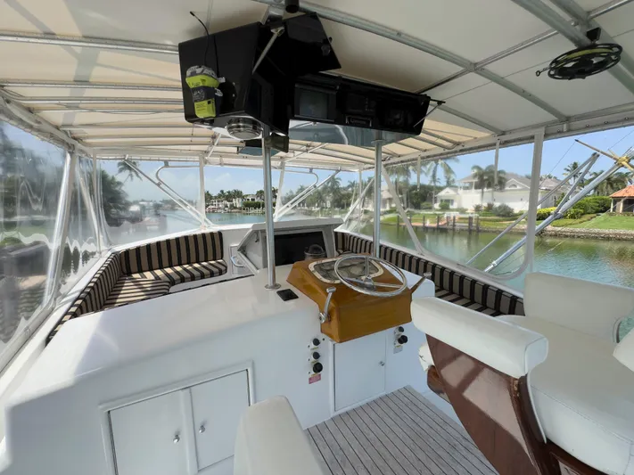 Vintage 1990 Yacht Photos Pics 1990 Buddy Davis 61 Convertible yacht helm with striped seating and waterfront view.