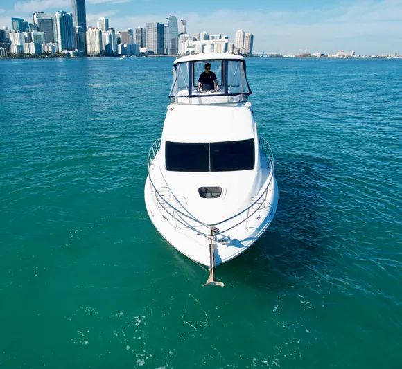  Yacht Photos Pics 2007 Sea Ray 360 Sedan Bridge yacht on turquoise water with city skyline in background.