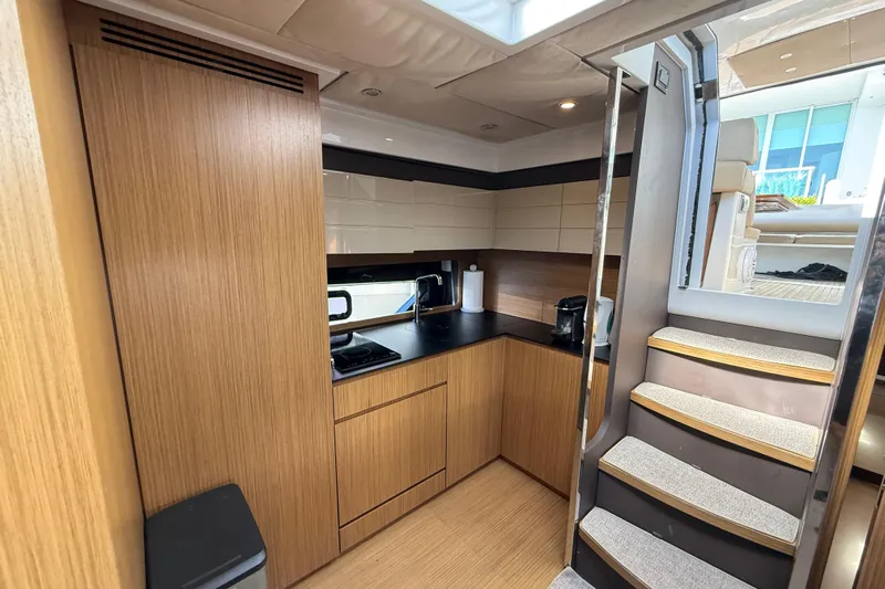  Yacht Photos Pics Modern kitchen interior of 2016 Azimut Atlantis 43 yacht with wooden cabinetry and stairs.