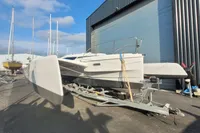 2019 Dragonfly 28 Performance trimaran on trailer near industrial building.