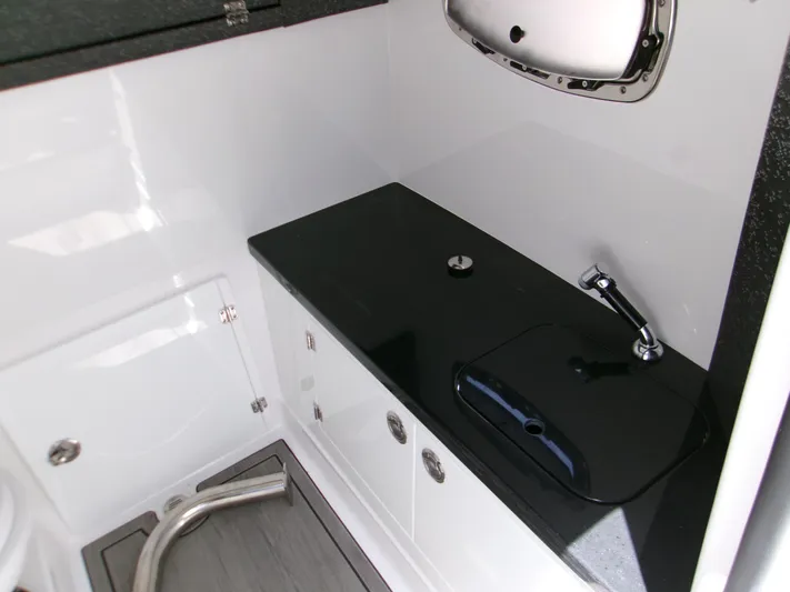  Yacht Photos Pics Interior of 2026 Monterey Elite 27 OB boat featuring sleek black countertop and modern fixtures.