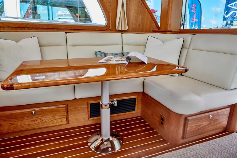 On Order, Ready For Customization Yacht Photos Pics Interior of 2027 Sabre 45 Salon Express with wooden table and cushioned seating.