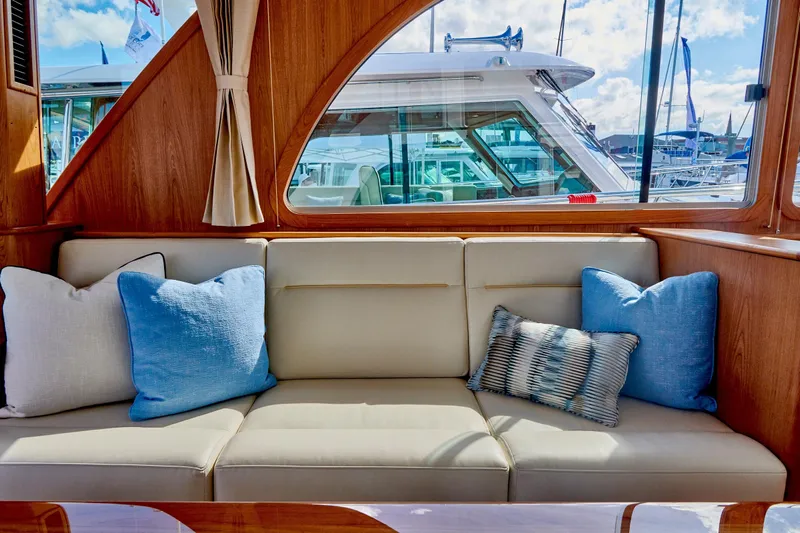 On Order, Ready For Customization Yacht Photos Pics Interior of Sabre 45 Salon Express 2027 with beige sofa and blue cushions.