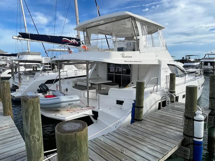 Nerdvana Yacht Photos Pics 2019 Leopard 51 Powercat docked at a marina with a small dinghy attached.