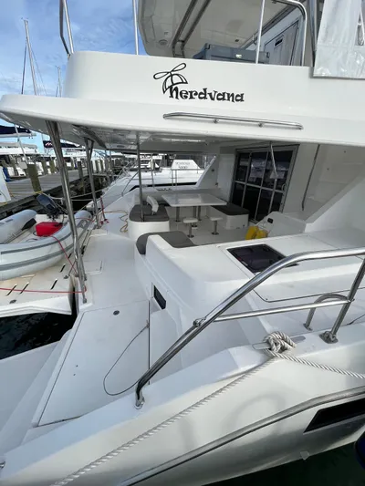 Nerdvana Yacht Photos Pics 2019 Leopard 51 Powercat yacht docked at marina, featuring spacious deck and seating area.
