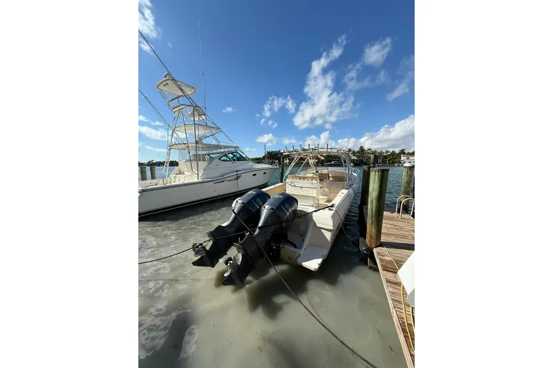  Yacht Photos Pics 2008 Intrepid 370 Cuddy boat docked with triple outboard engines under clear blue sky.