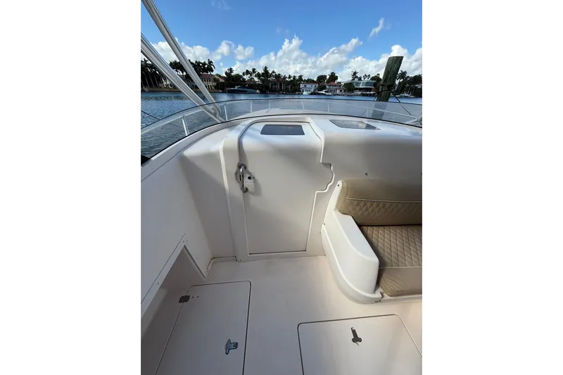  Yacht Photos Pics 2008 Intrepid 370 Cuddy boat interior with seating and storage, docked by waterfront homes.