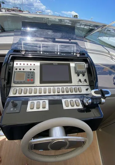  Yacht Photos Pics Control panel of a 2006 Riva RAMA 44' yacht with steering wheel and navigation equipment.