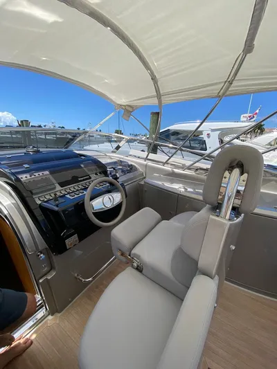  Yacht Photos Pics 2006 Riva RAMA 44' yacht cockpit with steering wheel and controls under canopy.