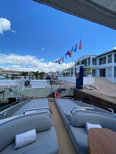  Yacht Photos Pics Luxury Riva RAMA 44' yacht docked, flags waving, clear blue sky, modern marina setting.