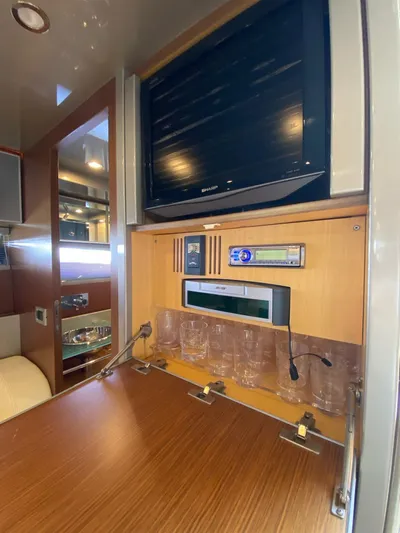  Yacht Photos Pics Interior of 2006 Riva RAMA 44' yacht with TV, audio system, and glassware storage.