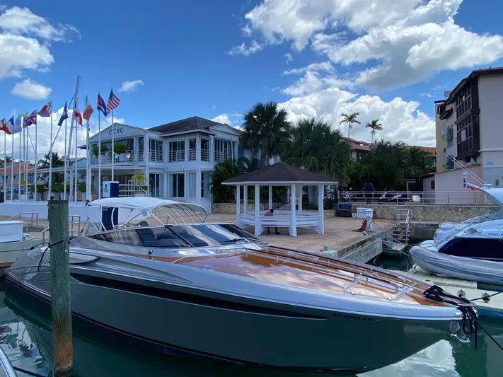  Yacht Photos Pics Luxury 2006 Riva RAMA 44' yacht docked at marina with flags and palm trees.