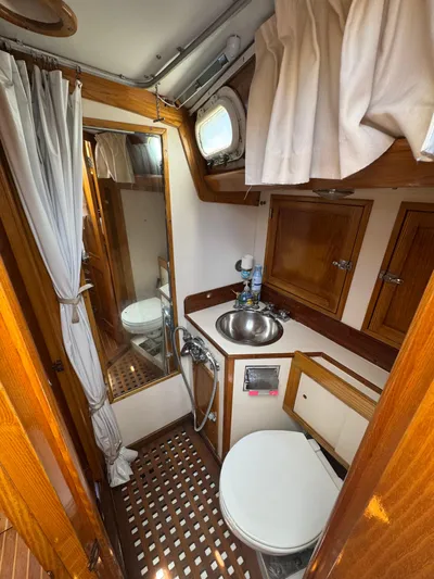 Mast Transit Yacht Photos Pics Hinckley Sou'wester 42 yacht bathroom, 1983 model, featuring wooden cabinetry and nautical decor.