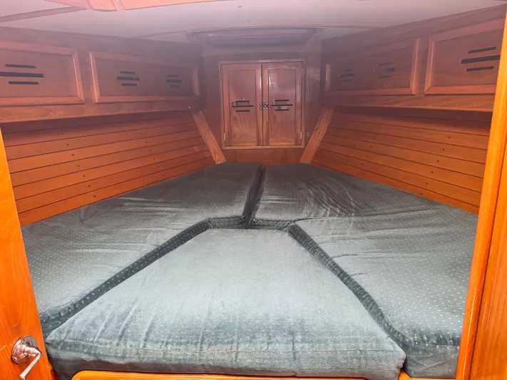 Mast Transit Yacht Photos Pics Cabin interior of 1983 Hinckley Sou'wester 42 with wooden paneling and cushioned bed.