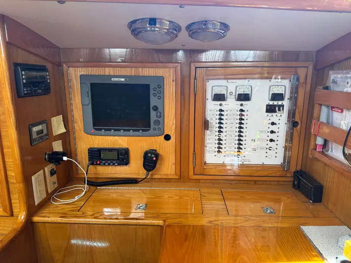 Mast Transit Yacht Photos Pics Navigation and control panel inside 1983 Hinckley Sou'wester 42 yacht, featuring wood finish and electronic equipment.