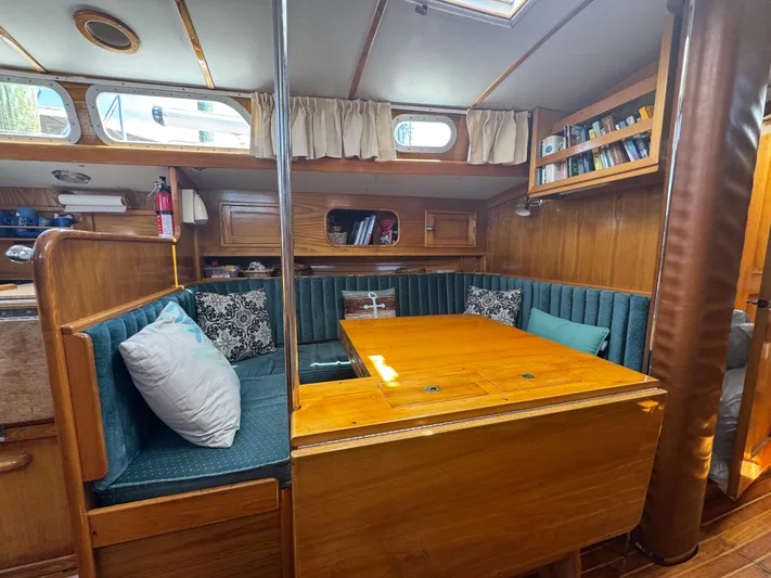 Mast Transit Yacht Photos Pics Interior of 1983 Hinckley Sou'wester 42 sailboat with wooden dining area and cushioned seating.