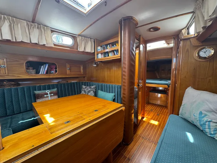 Mast Transit Yacht Photos Pics Interior of 1983 Hinckley Sou'wester 42 sailboat with wood paneling and cozy seating area.