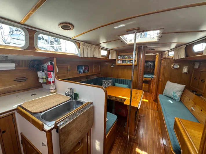 Mast Transit Yacht Photos Pics Interior of 1983 Hinckley Sou'wester 42 sailboat, featuring wood finishes and cozy seating area.
