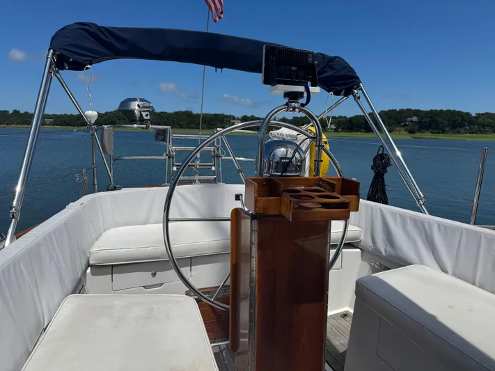 Mast Transit Yacht Photos Pics Cockpit of 1983 Hinckley Sou'wester 42 sailboat with steering wheel and seating, on calm water.