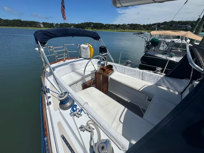 Mast Transit Yacht Photos Pics 1983 Hinckley Sou'wester 42 sailboat cockpit with seating, steering wheel, and American flag.