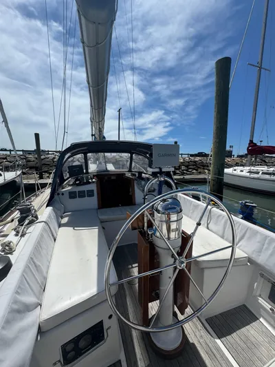 Mast Transit Yacht Photos Pics 1983 Hinckley Sou'wester 42 sailboat cockpit with steering wheel, docked under blue sky.