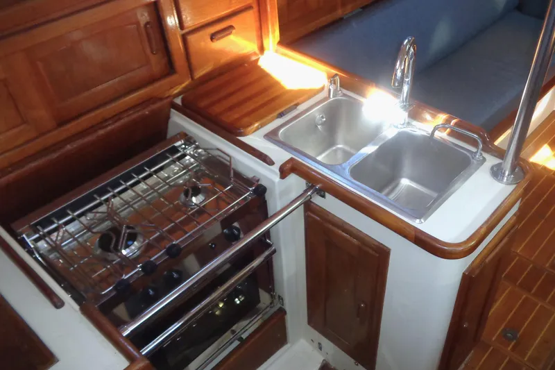 Yacht Photos Pics Galley kitchen in 1992 Pacific Seacraft 34 sailboat with stove and double sink.