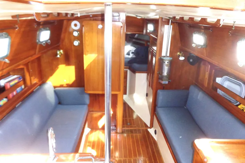  Yacht Photos Pics Interior of 1992 Pacific Seacraft 34 sailboat with wooden finish and blue seating.