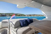 Luxurious 2009 Maiora 31 yacht deck with seating, table, and scenic ocean view.